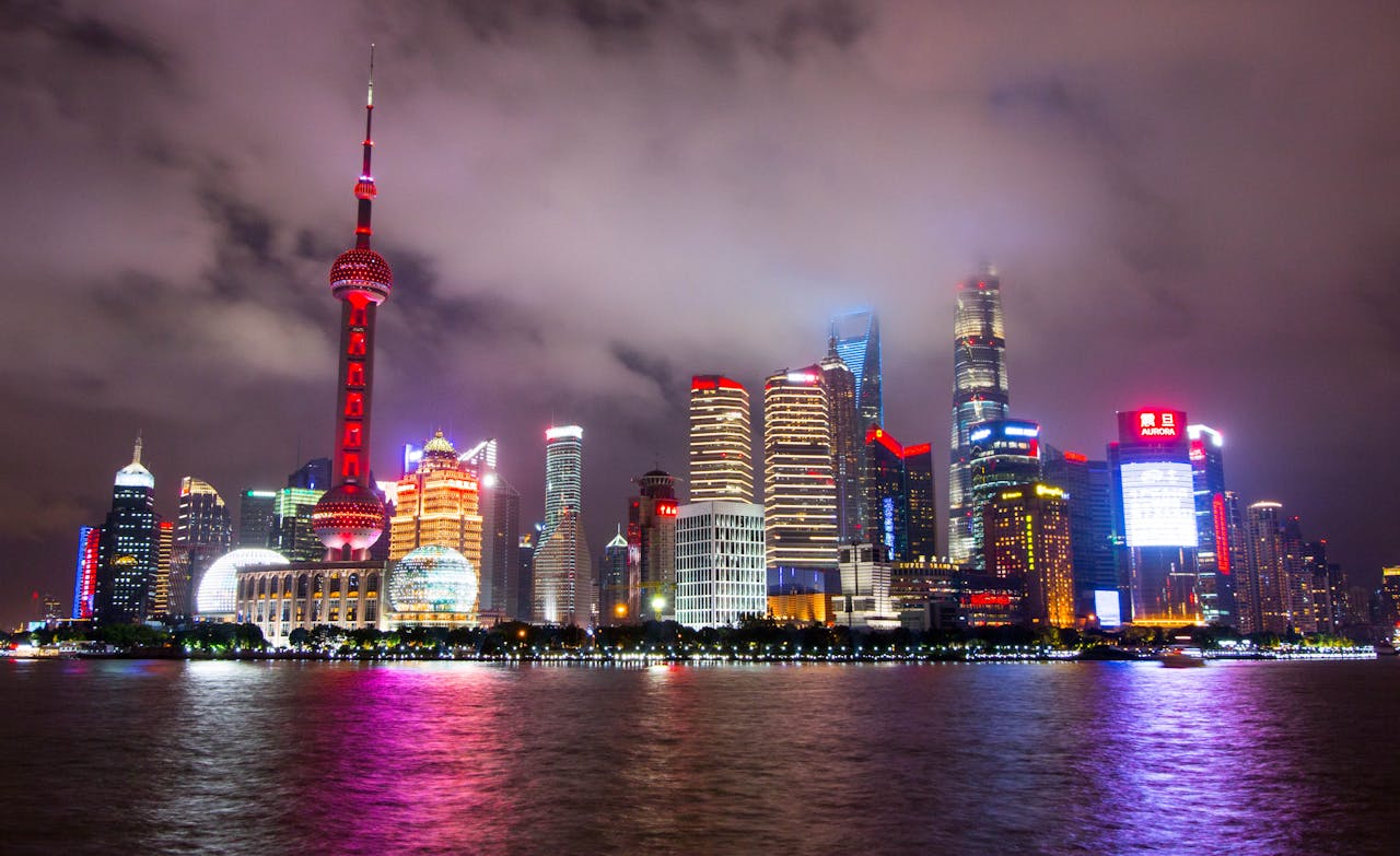 Captivating view of Shanghai's illuminated skyline reflecting on the waterfront at night.